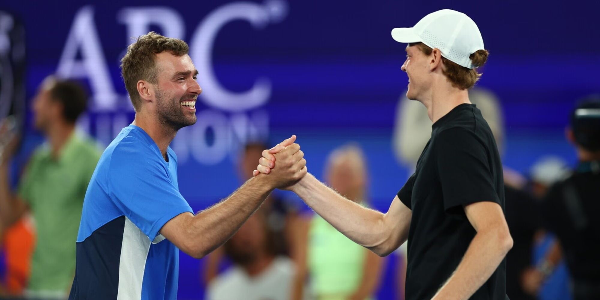 Jannik Sinner stringe la mano a Jordan Smith dopo il servizio in rete